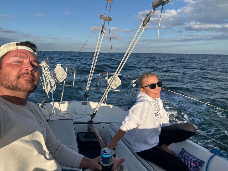 Cait on the sailboat with a friend at the helm